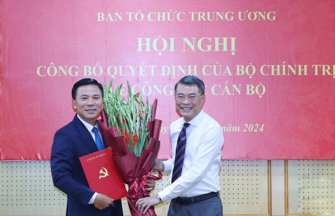 Ủy viên Bộ Chính trị, Bí thư Trung ương Đảng Trưởng ban Tổ chức Trung ương Lê Minh Hưng trao quyết định và chúc mừng ông Đỗ Trọng Hưng, tân Phó trưởng Ban Tổ chức Trung ương. Ảnh TTXVN.