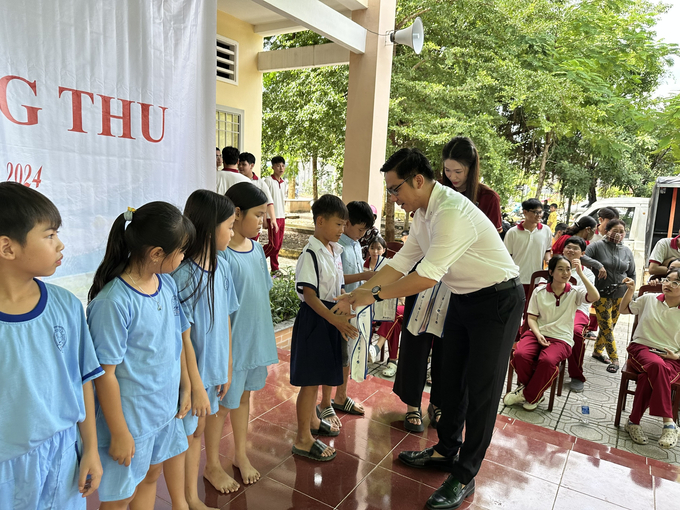 Ông Nguyễn Võ Hoàng Anh, Phó Tổng Giám đốc CTCP AMEI Việt Nam trao quà cho các em. (Ảnh Xuân Nhi)