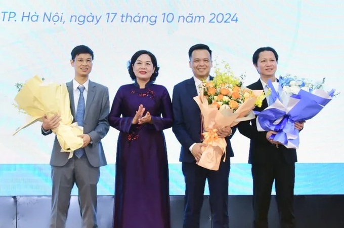 Thống đốc NHNN Việt Nam tặng hoa chúc mừng ông Nguyễn Trần Mạnh Trung (thứ hai từ phải sang) và ông Nguyễn Việt Dũng (ngoài cùng bên trái).