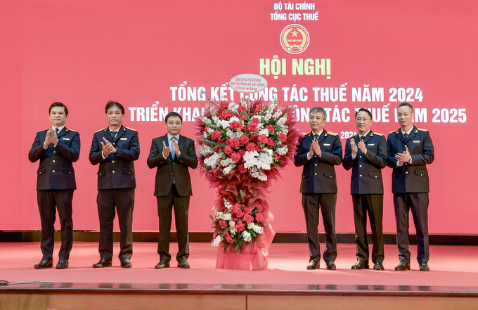 Bộ trưởng Bộ Tài chính Nguyễn Văn Thắng tặng hoa, chúc mừng lãnh đạo Tổng cục Thuế.