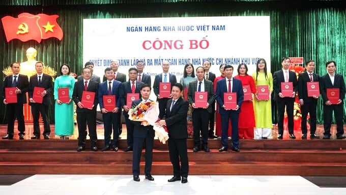 Ông Phạm Tiến Dũng - Phó Thống đốc Ngân hàng Nhà nước Việt Nam trao quyết định bổ nhiệm và tặng hoa chúc mừng ông Lê Anh Xuân - Giám đốc Ngân hàng Nhà nước - Khu vực 9 (ảnh PN)