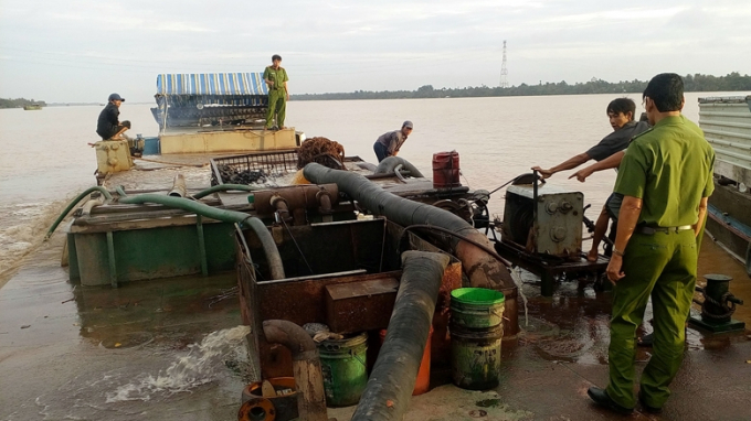 Lực lượng chức năng tỉnh Vĩnh Long bắt giữ một sà-lan trọng tải lớn hút trộm cát trên sông. Ảnh: Nhân dân