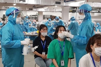 Nhân viên y tế lấy mẫu xét nghiệm COVID-19 cho công nhân ở Bắc Giang