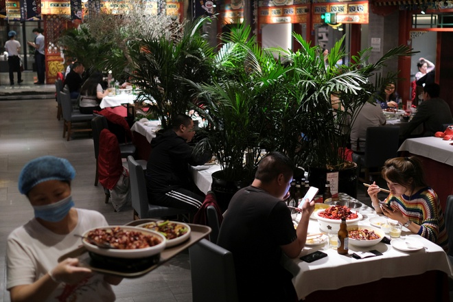 Nhân viên phục vụ và thực khách tại một nhà hàng ở Bắc Kinh hôm 7/5. Ảnh: Reuters.