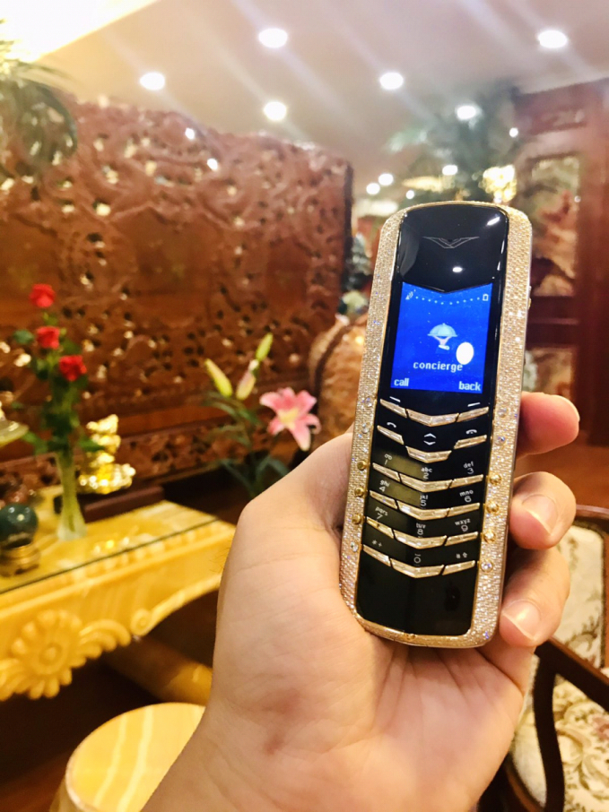 Đây là chiếc điện thoại Vertu của ông Minh. Nó là một trong những chiếc điện thoại Vertu đầu tiên trên thế giới và Việt Nam, được Ông Minh đặt riêng với hãng Vertu từ năm 2005, làm từ vàng khối và đính hơn 1000 viên kim cương trên thân máy và bàn phím.