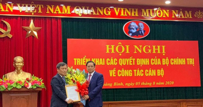 Ông Phạm Minh Chính - Trưởng Ban Tổ chức Trung ương trao quyết định, tặng hoa cho tân Bí thư Tỉnh ủy Quảng Bình Vũ Đại Thắng (bên trái)