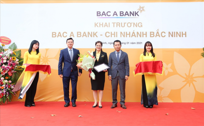 Ông Đặng Trung Dũng - Phó TGĐ Thường trực Ngân hàng TMCP Bắc Á (phải) trao quyết định và tặng hoa cho BAC A BANK Chi nhánh Bắc Ninh.