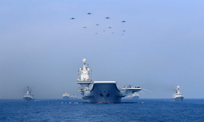 Tàu sân bay Liêu Ninh cùng các chiến hạm và máy bay Trung Quốc phô trương lực lượng trên Biển Đông, tháng 4/2018. Ảnh: Reuters.