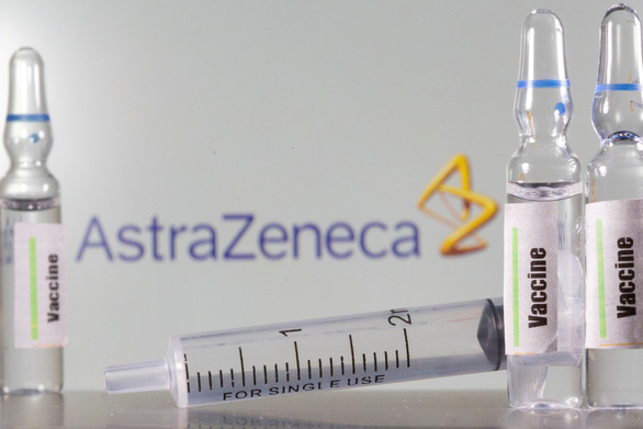 Các lọ đề chữ vắc xin đặt trước logo của Công ty AstraZeneca - Ảnh: REUTERS
