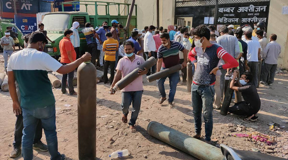 Mọi người xếp hàng bên ngoài các điểm cung cấp và nạp lại bình oxy ở thành phố Kanpur, Ấn Độ - Ảnh: INDIAN EXPRESS