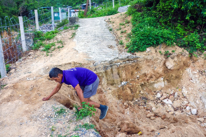 Con đường bị doanh nghiệp dùng máy múc phá nát, đào hố sâu 2 m khiến người dân phải vất vả khi đi lại.