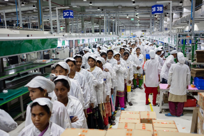 Đội ngũ lao động nữ xếp hàng để vào vị trí, nơi họ sẽ làm một công việc nhàm chán suốt 8 giờ đồng hồ. Ảnh: Bloomberg