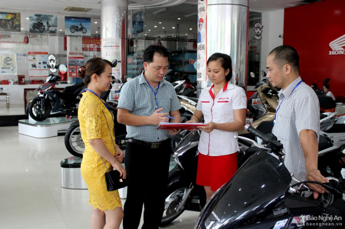 Cán bộ Chi cục Thuế Vinh kiểm tra chống thất thu thuế trong buôn bán xe máy. Ảnh: Quang An
