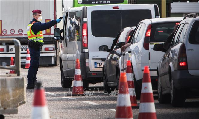 Cảnh sát kiểm tra thân nhiệt của người dân nhằm ngăn dịch COVID-19 lây lan, tại cửa khẩu Nickelsdorf/Hegyeshalom, biên giới Áo - Hungary, ngày 14/3/2020. Ảnh: AFP/TTXVN