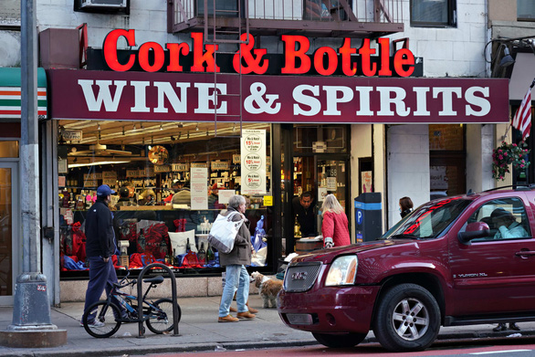 Khách hàng đứng chờ trước cửa hàng rượu Cork & Bottle tại thành phố New York ngày 21-3-2020 - Ảnh: GETTY IMAGES