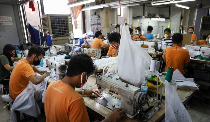 Người lao động Philippine trong một cơ sở sản xuất đồ bảo hộ y tế ở Manila. Ảnh: EPA.