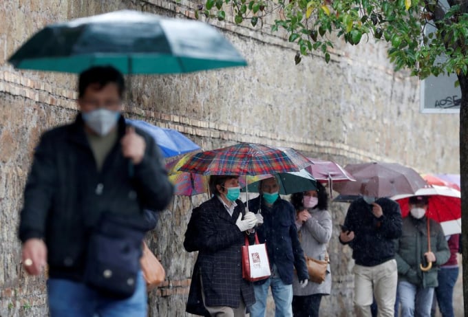Người dân xếp hàng chờ nhận miễn phí khẩu trang mua từ Trung Quốc tại Rome, Italy, hôm 22/4. Ảnh: Reuters.