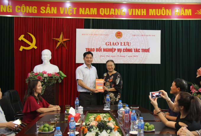 Chủ tịch VTCA Nguyễn Thị Cúc trao tặng sách về nghiệp vụ thuế cho Chi cục trưởng Tạ Văn Quân