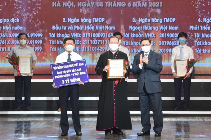 Thủ tướng Chính phủ Phạm Minh Chính tặng hoa cho các cá nhân ủng hộ Quỹ vaccine phòng COVID-19.