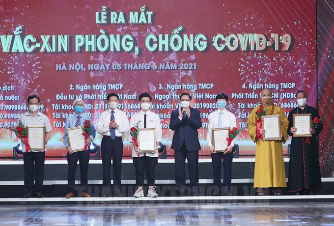 Thủ tướng Chính phủ Phạm Minh Chính tặng hoa cho các cá nhân ủng hộ Quỹ Vắc-xin phòng chống Covid-19.