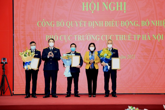 Bà Nguyễn Thị Tuyến - Phó Bí thư thường trực Thành ủy Hà Nội và ông Cao Anh Tuấn, Tổng cục trưởng Tổng Cục thuế trao quyết định và hoa cho Tân Phó cục trưởng Cục Thuế Hà Nội.