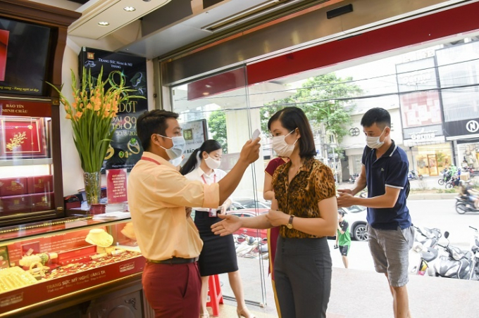 Các cửa hàng Bảo Tín Minh Châu có nhân viên y tế đo thân nhiệt và hướng dẫn các biện pháp phòng vệ dịch cho khách hàng.