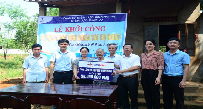 Ông Phan Văn Vĩnh - Giám đốc PC Quảng Trị (thứ ba bên phải) trao biểu trưng số tiền 50 triệu đồng hỗ trợ xây dựng nhà tình nghĩa cho bà Trần Thị Thảnh ở thôn Mai Đàn, xã Cam Chính (huyện Cam Lộ)