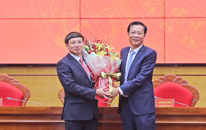 Ông Nguyễn Xuân Ký (bên trái), tân Bí thư Tỉnh ủy Quảng Ninh nhận hoa chúc mừng từ người tiền nhiệm, ông Nguyễn Văn Đọc.