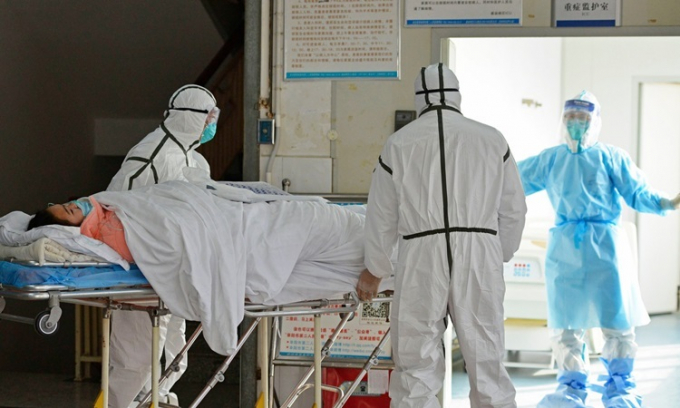 Các bác sĩ chuyển bệnh nhân nhiễm nCoV vào khu vực cách ly ở bệnh viện thành phố Phụ Dương, tỉnh An Huy - Ảnh: AP.
