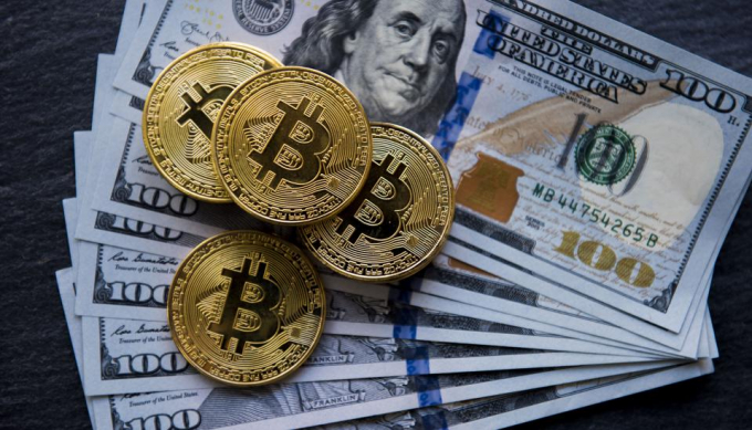 Lo ngại Cục dữ trữ liên bang Mỹ và các ngân hàng trung ương sẽ nỗ lực giảm giá trị đồng USD, nhiều người đã mua số lượng lớn Bitcoin. Ảnh: The Guardian