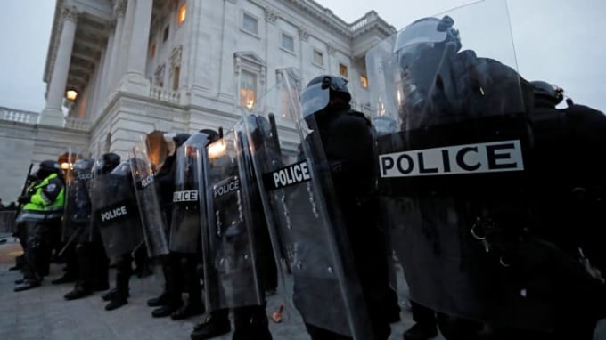 Cảnh sát chống bạo động lập hàng rào xung quanh Điện Capitol khi người ủng hộ Tổng thống Donald Trump tràn vào phòng họp của các nghị sĩ vào chiều 6/1. Ảnh: Reuters