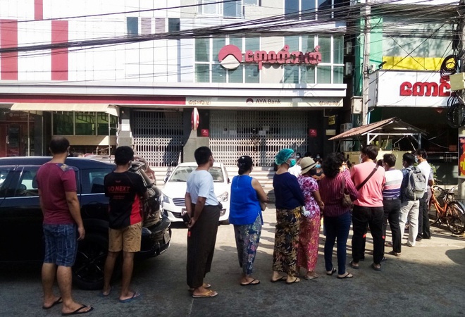 Người dân Myan xếp hàng trước một chi nhánh ngân hàng ở Yangon để chờ rút tiền vào ngày 1/2. Ảnh: Reuters.