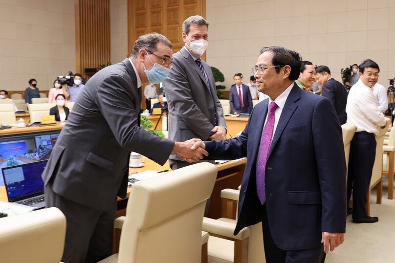 PM Pham Minh Chinh (right) shakes hands with a foreign delegate at the conference on capital market development on April 22, 2022. Photo courtesy of the government’s portal.