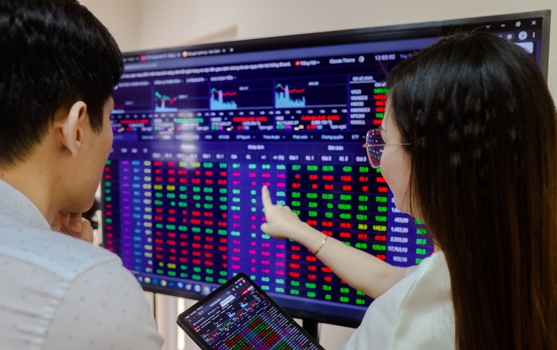 Investors look at stock prices on a screen. Photo by The Investor/Trong Hieu.
