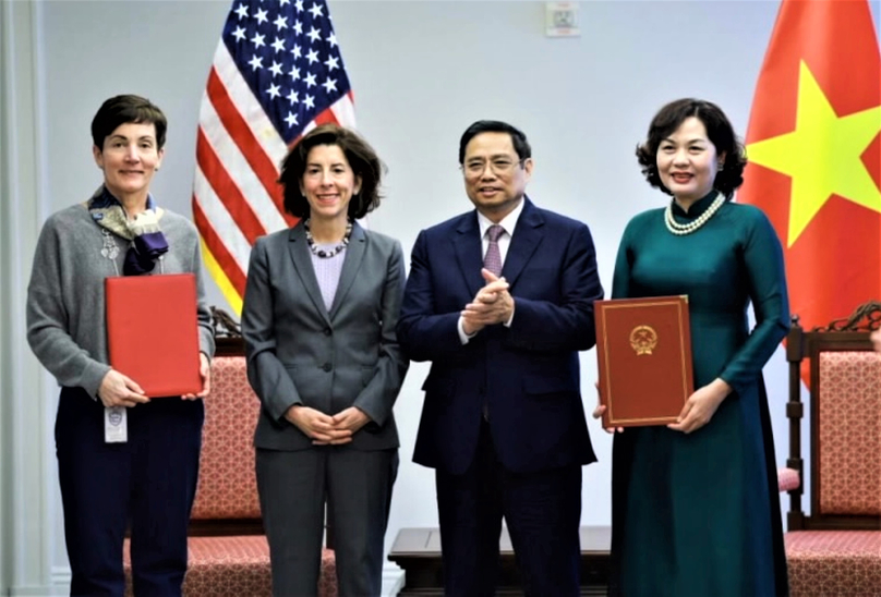  IFC's Senior Vice President Stephanie von Friedeburg (L) and State Bank of Vietnam Governor Nguyen Thi Hong (R) exchange their signed MoU in Washington on May 11, 2022, witnessed by Vietnamese Prime Minister Pham Minh Chinh (2nd, R) and U.S. Secretary of Commerce Gina Raimondo. Photo courtesy of the State Bank.