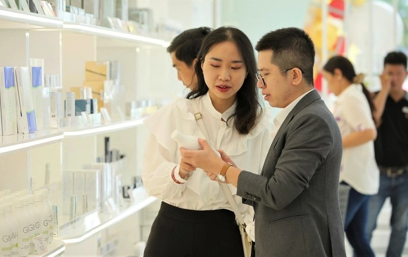 An Amway Vietnam employee (L) helps a visitor get to know about Amway products at the center opening ceremony on June 24, 2022 in Can Tho city, southern Vietnam. Photo courtesy of the Vietnamese government’s portal.