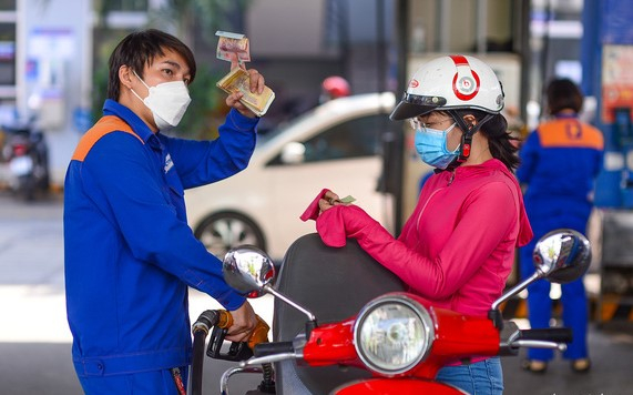 A motorcyclist (R) gets refilled at a gasoline station in Ho Chi Minh City. Photo courtesy of Tuoi Tre newspaper.