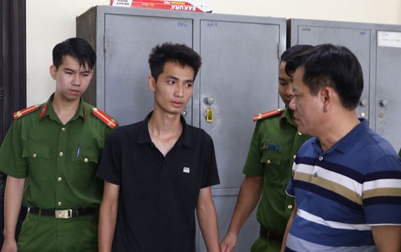 Nguyen Truong Giang (in black) at the police station. Photo courtesy of Ha Nam newspaper.