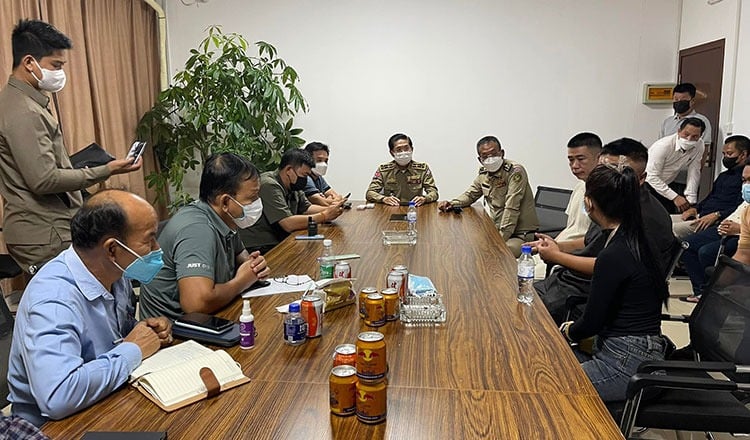 Cambodia's immigration officers speak with representatives from the casino (right). Photo courtesy of Khmer Times.