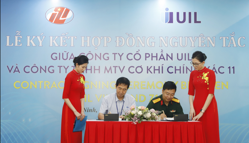 Representatives of UIL Vietnam JSC and Z111 Factory sign a sim trays manufacturing agreement. Photo courtersy of the General Department of Defense Industry.