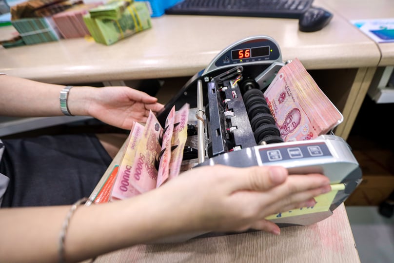 A clerk counts Vietnamese dong notes at a bank in Hanoi. Photo by The Investor/Trong Hieu.