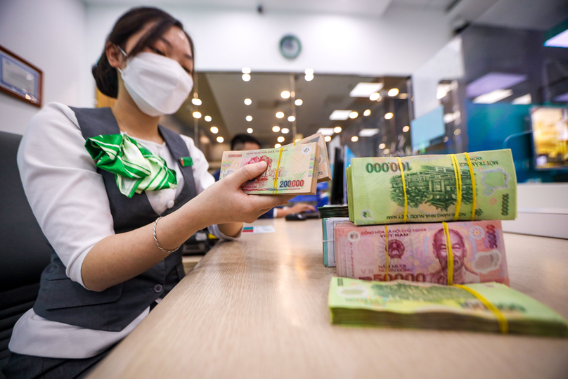 A tellers counts money at a transaction office of VPBank. Photo by The Investor/Trong Hieu.