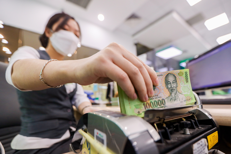 A clerk is counting dong bills at a bank branch in Hanoi. Photo by The Investor/Trong Hieu.