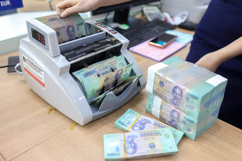 A bank clerk counts VND bank notes at a transaction office in Hanoi. Photo by The Investor/Trong Hieu.