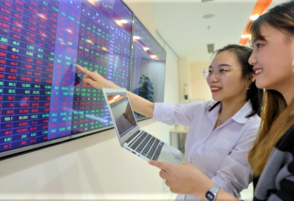 Two investors watch stock prices at a brokerage in Vietnam. Photo courtesy of VietnamFinance.