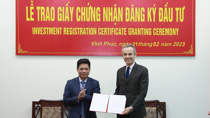 Nguyen Xuan Phuong (left), head of Vinh Phuc industrial zone authority, grants the investment registration certificate to Gianluca Fiume, CEO of Piaggio Vietnam.