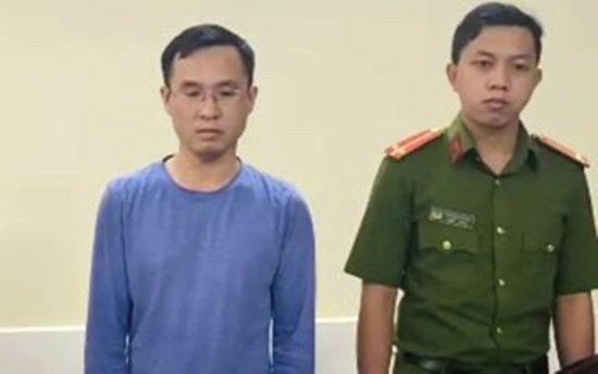 Mai Van Quan (left) at the investigative agency. Photo courtesy of Ho Chi Minh City Police.