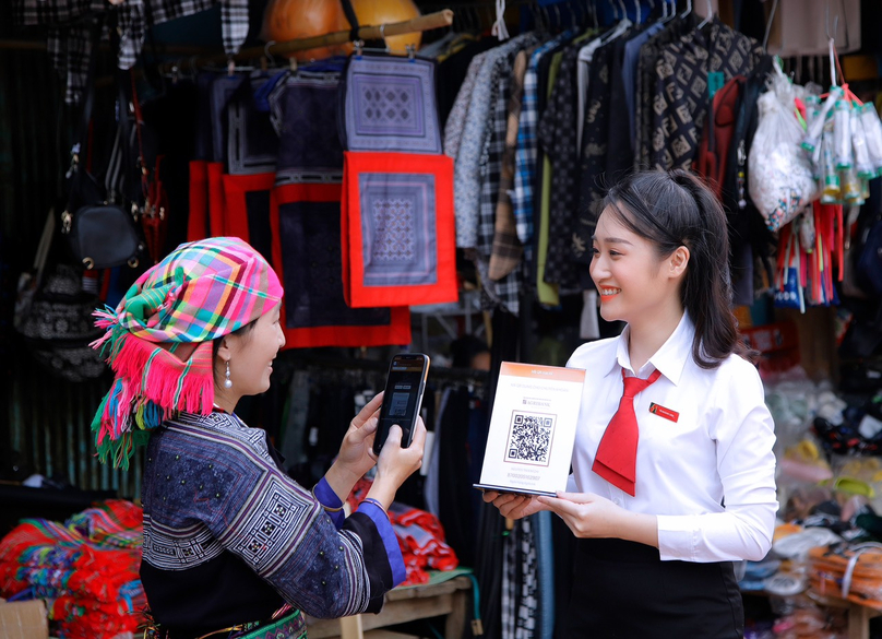 An Agribank staff member shows a QR code to an ethnic woman to make transactions. Photo courtesy of the bank.