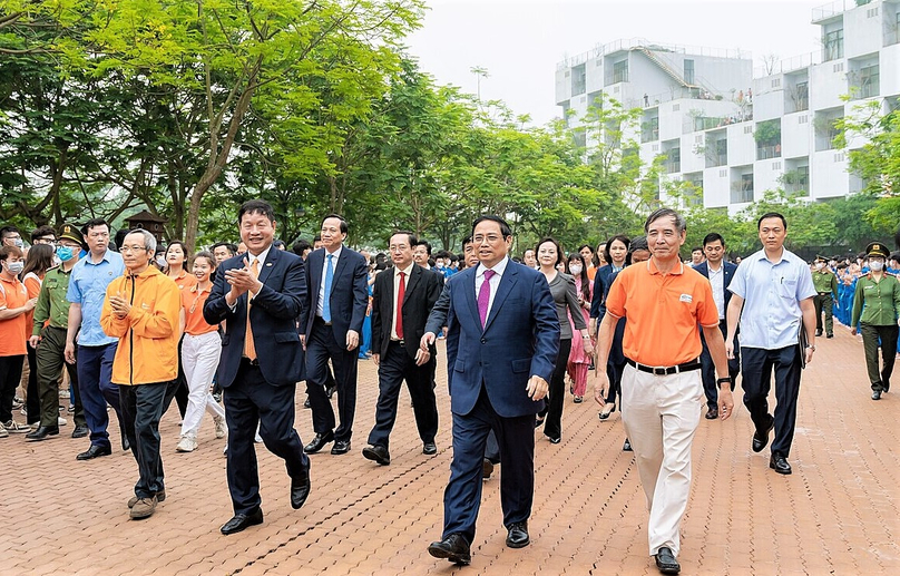 FPT Group chairman Truong Gia Binh (in black suit, clapping) welcomes Prime Minister Pham Minh Chinh (front, in dark blue) to an FPT Software hub in Hoa Lac High-tech Park in Hanoi, northern Vietnam on April 14, 2023. Photo courtesy of FPT.