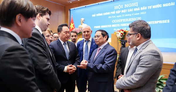 Prime Minister Pham Minh Chinh talks with foreign investors at the conference. Photo courtesy of the government portal.